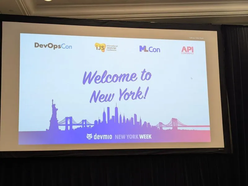 Conference screen showing Welcome to New York with the logos of DevOpsCon, iJS, ML Con and API Conference