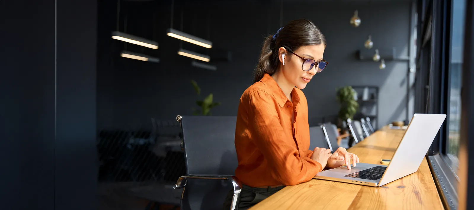An employee working with concentration on a laptop in a modern office